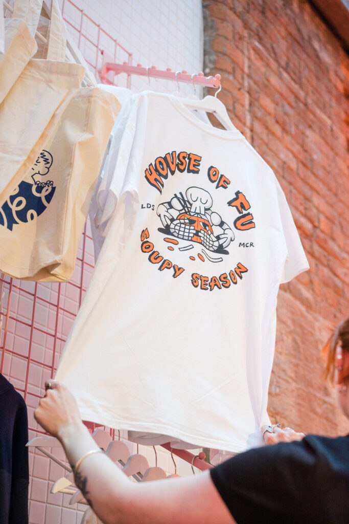 A white and orange House of Fu graphic tee from our Halloween merchandise collection. The graphic print reads 'House of Fu' and 'Soupy Season' with a cartoon Pumpkin and skeleton illustration.